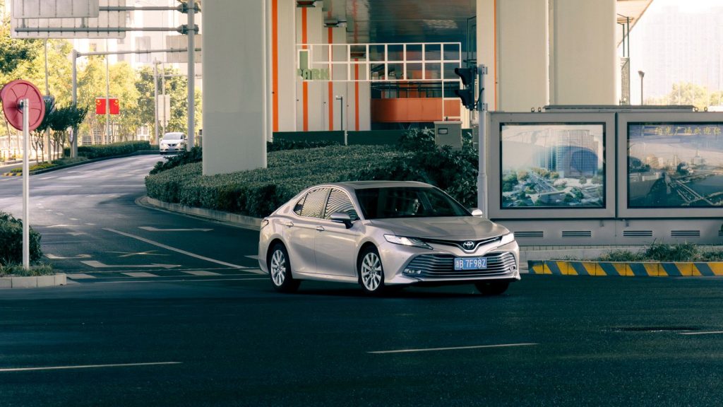 Used sedan from China with a Chinese registration plate on a modern city road